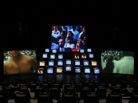 Gretchen Bender, 8‑channel video installation: 24 monitors, 3 projections, color, sound. 108 x 180 x 360 in. (274.3 x 457.2 x 914.4 cm) 18:00 min. Estate of Gretchen Bender. Photo by Jason Mandella, Courtesy of The Kitchen, New York.