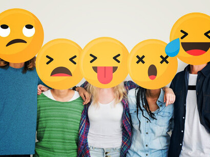 Individuals joyfully hold emoticons, showcasing the intersection of technology and communication in fostering happiness and connection