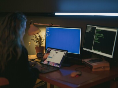A developer working at multiple computer screens, representing the integration of AI into everyday knowledge work