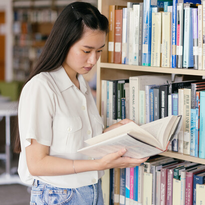 Futura escritora lê livro em biblioteca