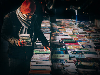 Hombre ojea algunos textos en un puesto de libros en una feria de Londres, Inglaterra