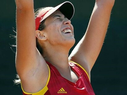 Garbiñe Muguruza levanta los brazos tras conseguir el punto definitivo que daba la victoria a España
