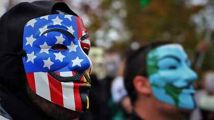 Close-up photo of person wearing Guy Fawkes mask, symbolizing anonymity and protest