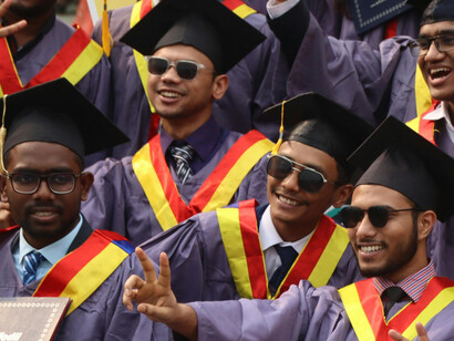A group of joyful graduates celebrating at a university convocation in India