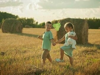 Un bambino e una bambina giocano in un campo di fieno