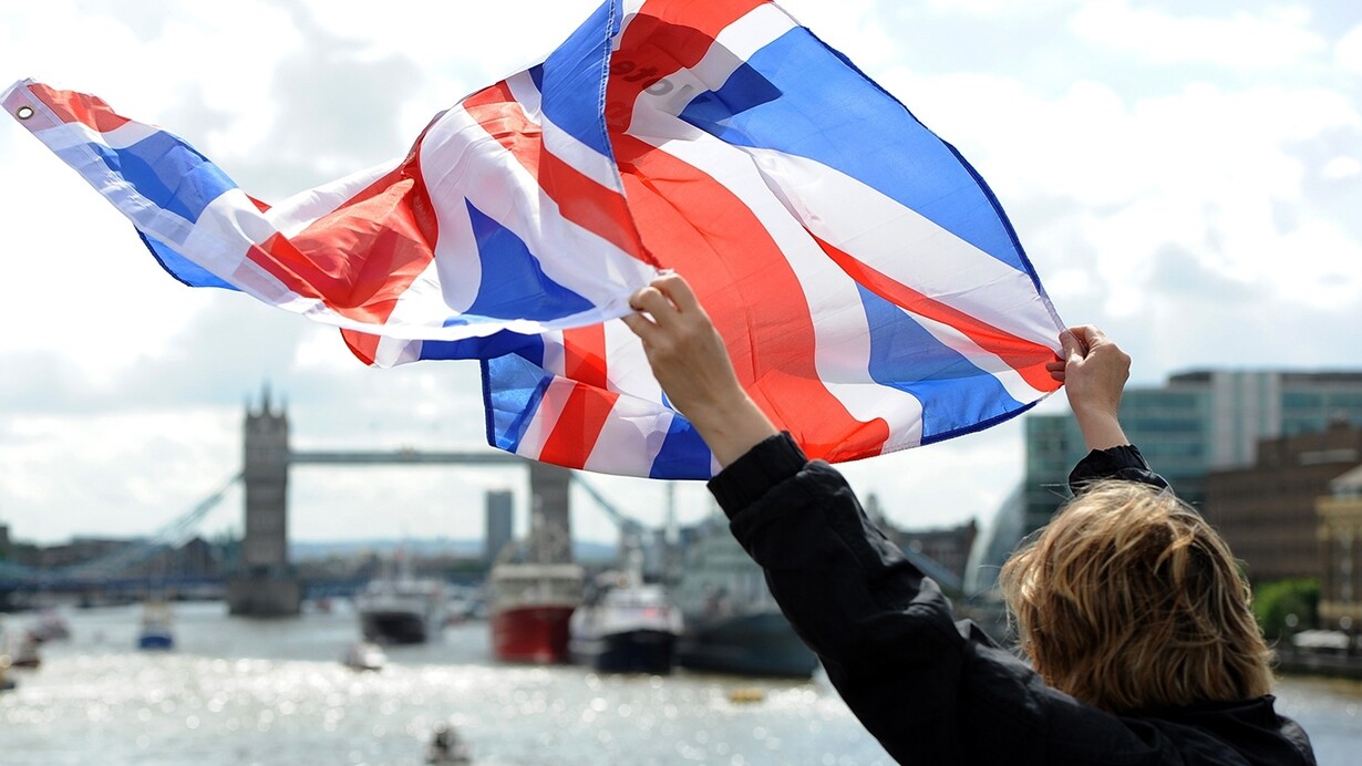 Saludando con una bandera británica sobre el Támesis