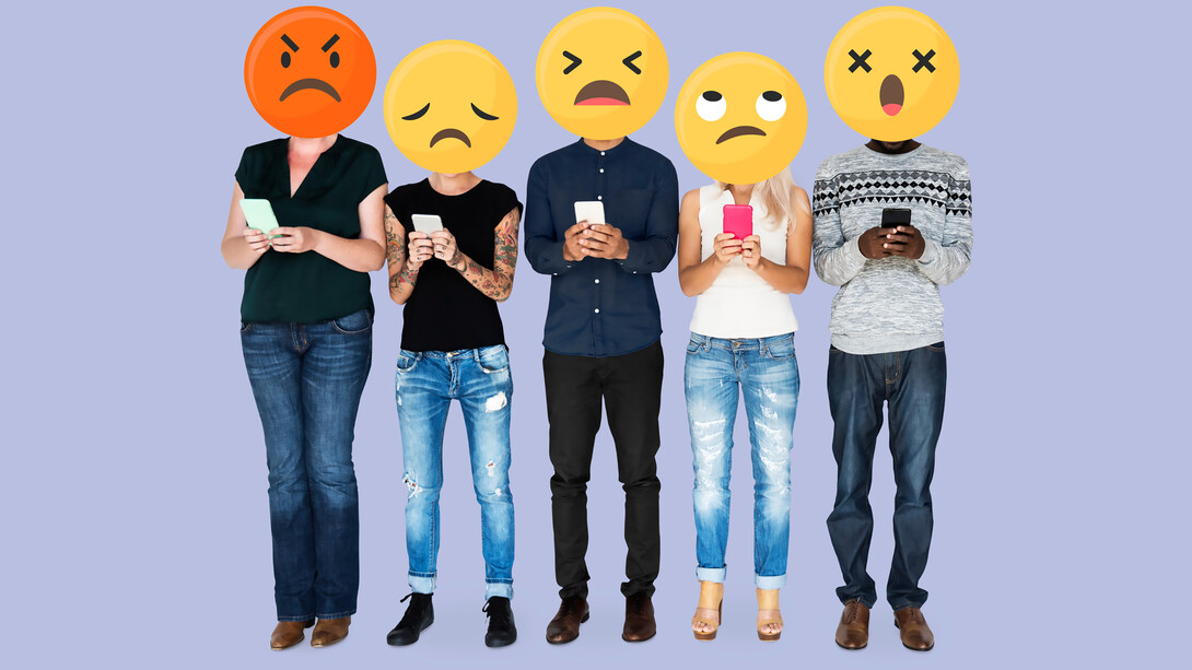 People holding emoji faces while making negative comments on social media, depicting trolling behavior in the online sphere