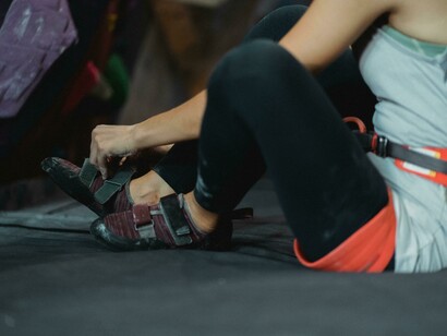 Cropped view of a woman putting on sneakers before bouldering