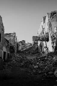 A ravaged city street, building turned to rubble