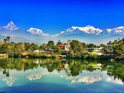 La città di Pokhara riflessa nel fiume Phewa vista da lontano, Nepal