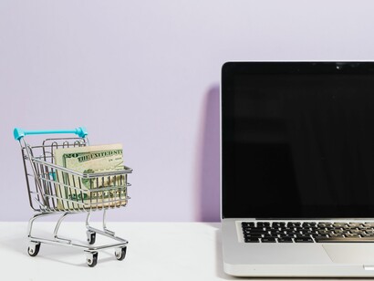 Carrinho de compras ao lado de laptop