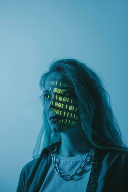 Mulher aparece envolvida por elementos visuais associados ao universo dos dados. A construção de sistemas mais justos depende de dados, equipes e processos mais diversos. O artigo argumenta que a IA tende a reproduzir padrões já existentes no mundo real. O desafio não é apenas tecnológico, mas também social e cultural