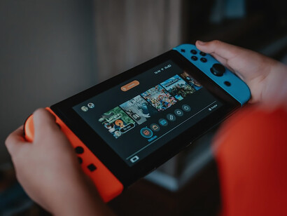 Person holding black and orange nintendo switch