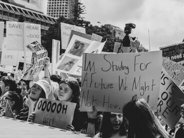 Black-and-white image capturing climate activists with protest placards during a demonstration in Sydney, New South Wales, Australia