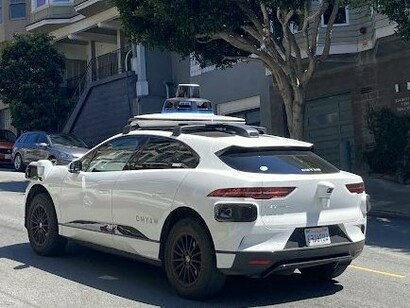 A Waymo autonomous vehicle navigates a San Francisco hill, showcasing the city's role as a pioneer in driverless transportation