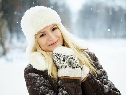 Bundled in cozy layers, a young woman embraces the snowfall—proof that winter joy doesn’t end with the holidays
