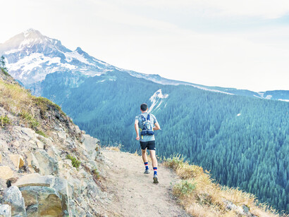 Hombre corriendo por la montaña. Correr aumenta la oxigenación y la posible aceleración de los latidos cardiacos iniciando un proceso de capilarización del cuerpo, músculos y cerebro
