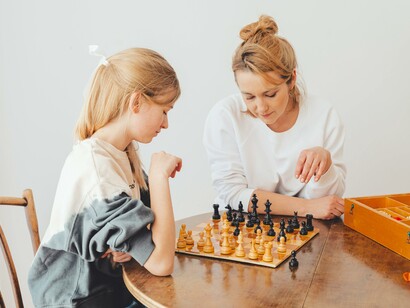 Mulher e uma garota jogando xadrez