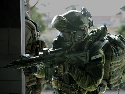 A soldier in the Polish Multi-role exploitation Reconnaissance Team (MRT) conducts a security check of the a building suspected of having hazardous material in Lisbon, Portugal on October 29, 2015 during NATO exercise