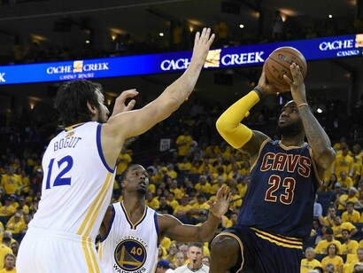 Andrew Bogut (Golden State) intenta poner un tapón a LeBron James (Cleveland)