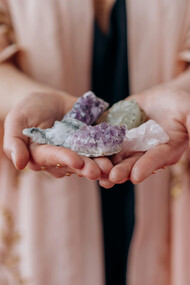 A woman holds healing crystals in her hands, channeling calm and positive energy