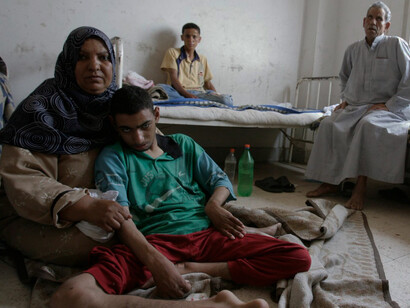 In Egypt, a woman sits on the floor with her son, Ashraf Azzoz, at a public hospital in the Sharqia province, located 260 km northeast of Cairo, on June 10, 2008