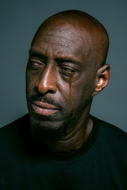 Man looking sideways as he sheds tears