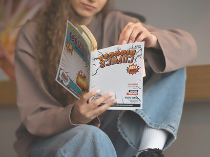 Marvel enthusiast engrossed in comic reading, highlighting graphic design innovation and cultural influence