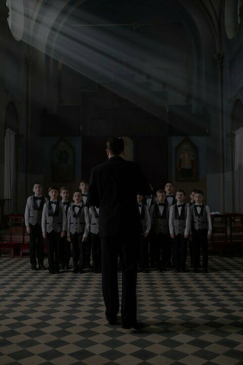 Un maestro dirige un coro di bambini. I giovani artisti sono bombardati dalla cultura della modestia, della dedizione, dell'impegno. Con questa nuova visione si tralascia però una variabile fondamentale dell’essere artista: il talento