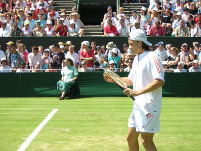 Guillermo Coria ajustant les cordes de sa raquette entre deux points lors d'un match du tournoi de Wimbledon en Angleterre le 21 juin 2005