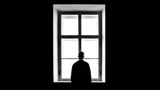 Hombre solitario mira por la ventana
