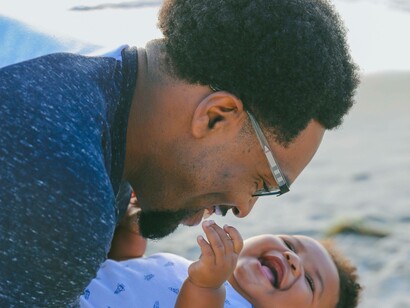 Father holds baby by the beach