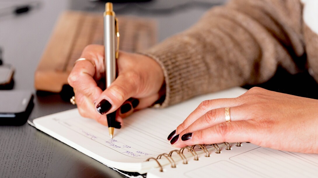 Mulher executiva escreve em sua agenda