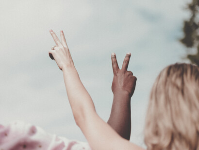 Un hombre y una mujer alzan sus manos con el famoso símbolo de 'paz y amor'