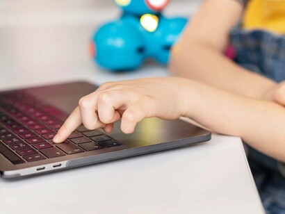 Primo piano delle mani di un bambino mentre digita sulla tastiera di un laptop