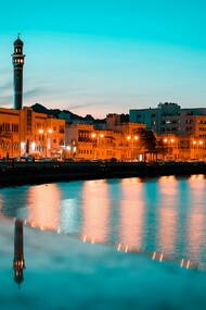 The Mutrah skyline in Muscat, Oman, glows beautifully against the night sky