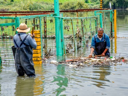 Men clearing debris in a flooded urban area, illustrating the growing impact of the climate crisis and extreme flooding