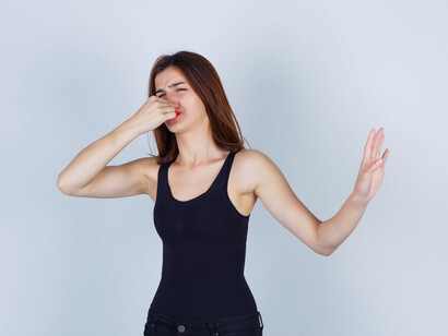 A woman in a black shirt reacting to an unpleasant smell, exploring human senses and the ethics of scent
