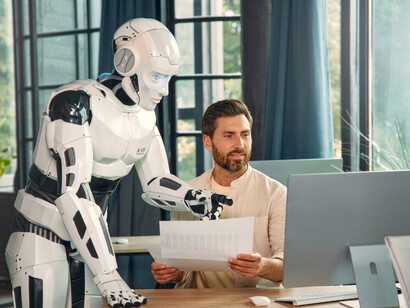 A man works alongside a humanoid robot in a modern home environment