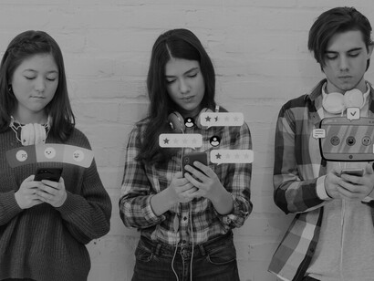 Socializing outdoors, friends effortlessly incorporate smartphones into their interactions, highlighting the seamless integration of technology into modern friendships