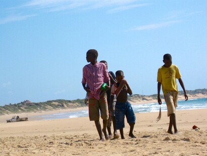 Children walking on the beach in Tofo, Mozambique