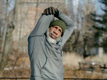 A senior Black male exercising outdoors in a fall setting, maintaining strength and well-being