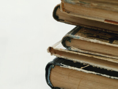 Detailed view of old books against a neutral background, ideal for showcasing literary themes