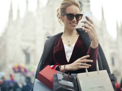 A woman holding shopping bags, representing the luxury lifestyle often portrayed by influencers