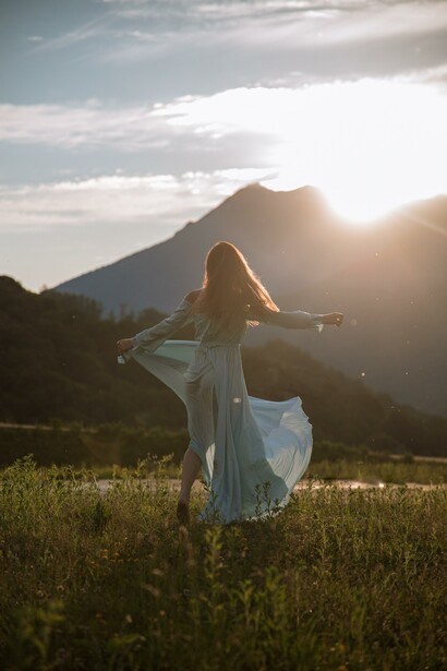 Person connecting with nature in a meadow in the evening