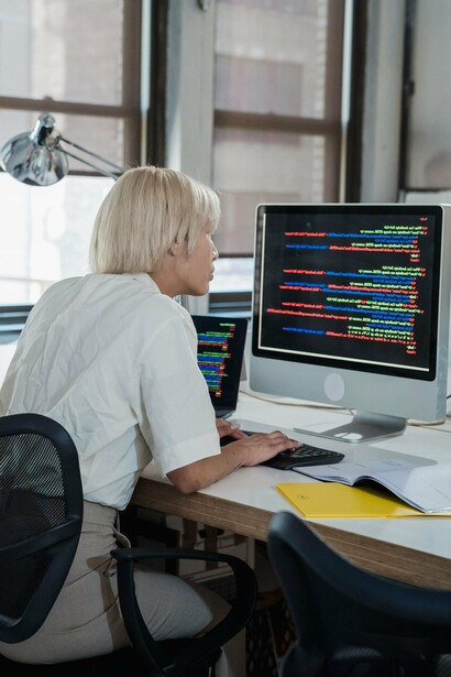 Programadora executa atividades técnicas em seu computador. O crescimento da inteligência artificial reacendeu o debate sobre igualdade de oportunidades no setor tecnológico. Especialistas defendem que sistemas mais inclusivos começam com equipas mais representativas. A diversidade de perspectivas ajuda a identificar problemas que poderiam passar despercebidos