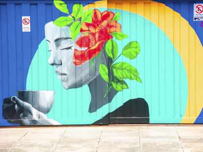 Mural de una joven con una taza de té en tonos turquesas y azules por la pintora boliviana “View the artist” y la muralista Leti Bonetti. Buenos Aires, Argentina