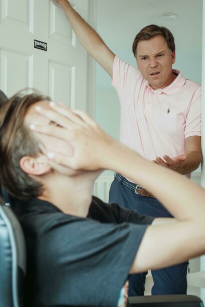 A father confronts his teenage son over his smartphone use at home