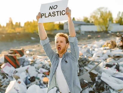 A man strongly grasps a paper sign that reads 'no plastic,' illustrating his commitment to the environmental movement and the battle against environmental damage, pollution, and climate change
