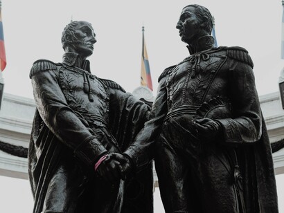 Monumento no Equador retrata o encontro histórico entre Simón Bolívar e José de San Martín, figuras decisivas nos processos de independência sul-americanos. O artigo aborda disputas de poder e projetos políticos que continuam a influenciar o destino da região